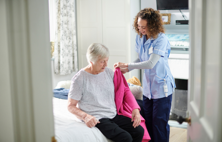 Carer helping a woman in her care home