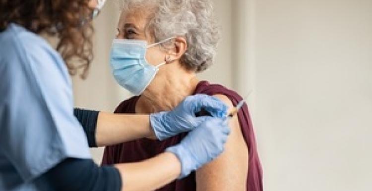An elderly woman receiving a vaccine