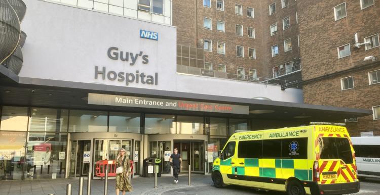 Exterior of Guy's Hospital with an ambulance out front.