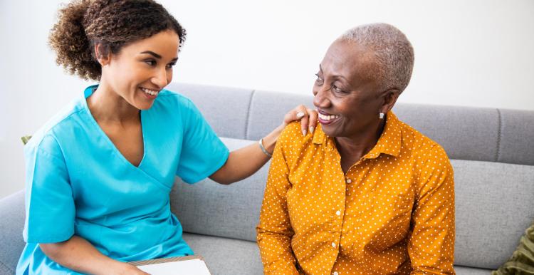 Nurse has placed her hand on the shoulder of another woman.