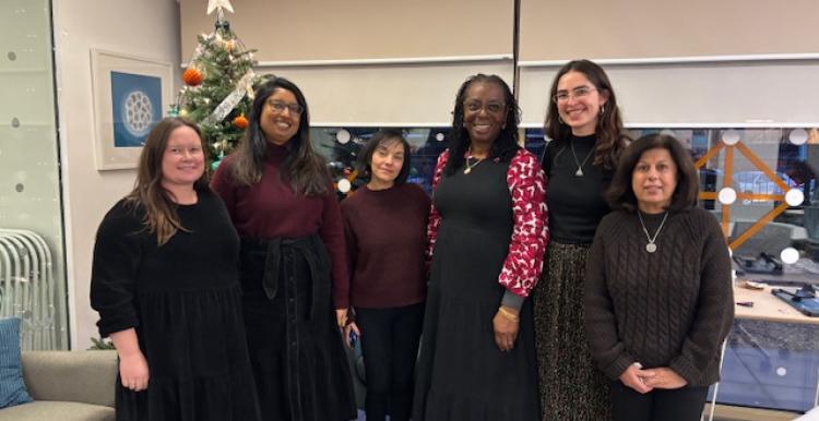 Six women standing in front of a Christmas Tree