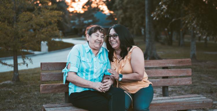 two ladies sitting on a bench and chatting
