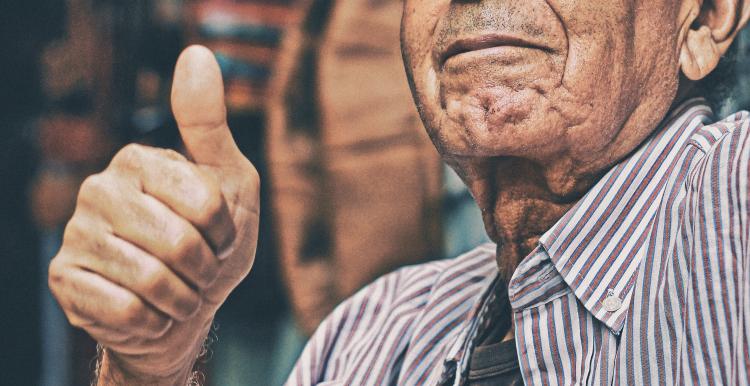 an old man with his thumbs up 