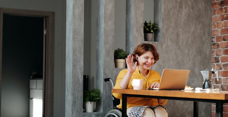 Women sitting in a wheel chair using a computer