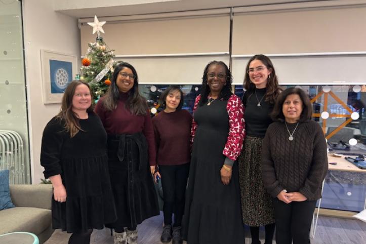 Six women standing in front of a Christmas Tree