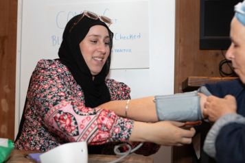 A Healthwatch representative helping a member of the public do a blood pressure test