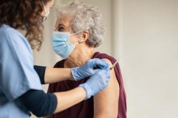 An elderly woman receiving a vaccine