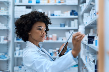 Pharmacist looking at shelf.