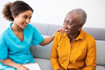 Nurse has placed her hand on the shoulder of another woman.