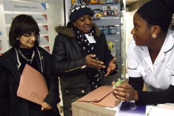 Two people speaking to a pharmacist