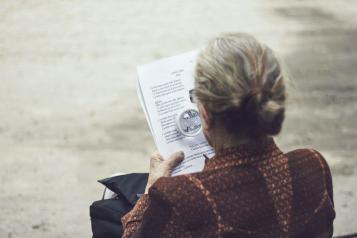 An older lady sitting on a bench