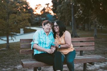 two ladies sitting on a bench and chatting