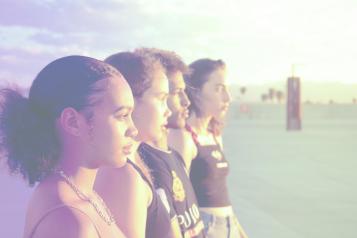 A group of young people standing next to each other and looking into the distance