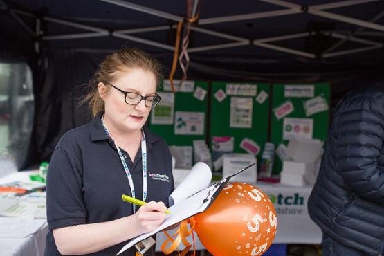Healthwatch staff member taking down notes from a member of the public
