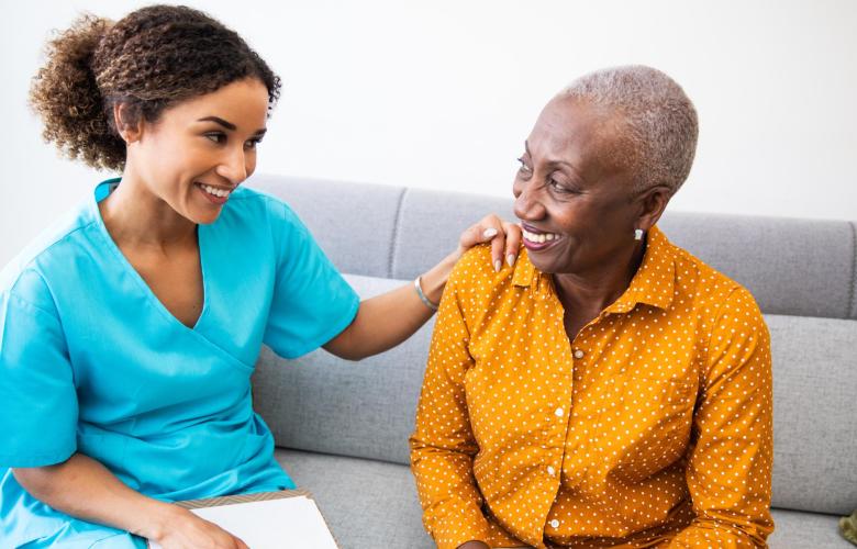 Nurse has placed her hand on the shoulder of another woman.