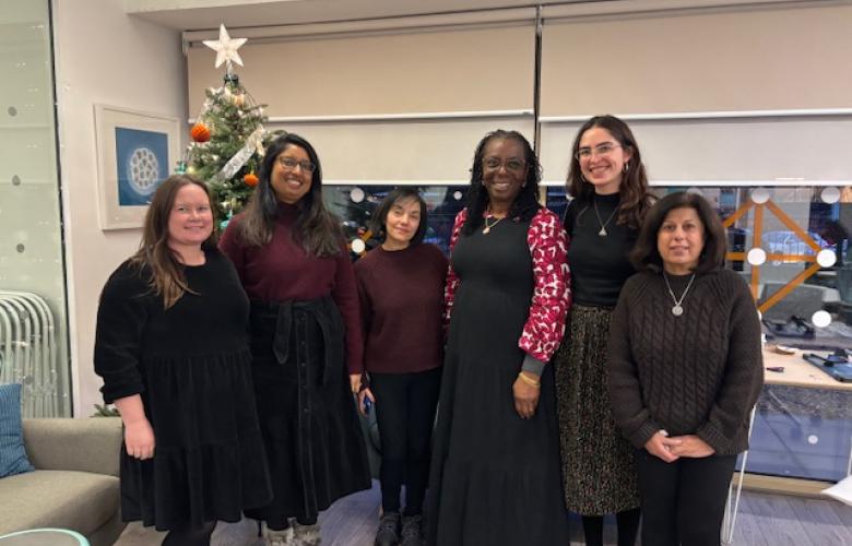 Six women standing in front of a Christmas Tree