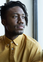 Serious black man looking out a window