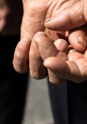 older person's hands folded behind their back